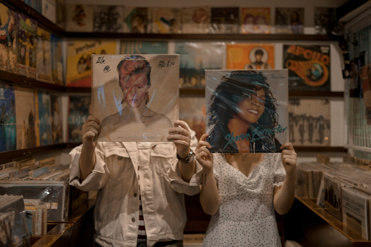 Two people holding records in a vinyl shop 