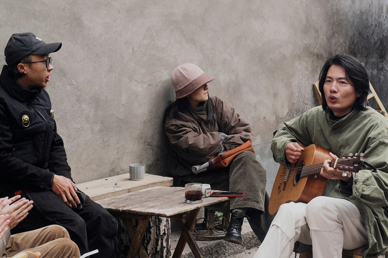 woman playing guitar while friends/family listen