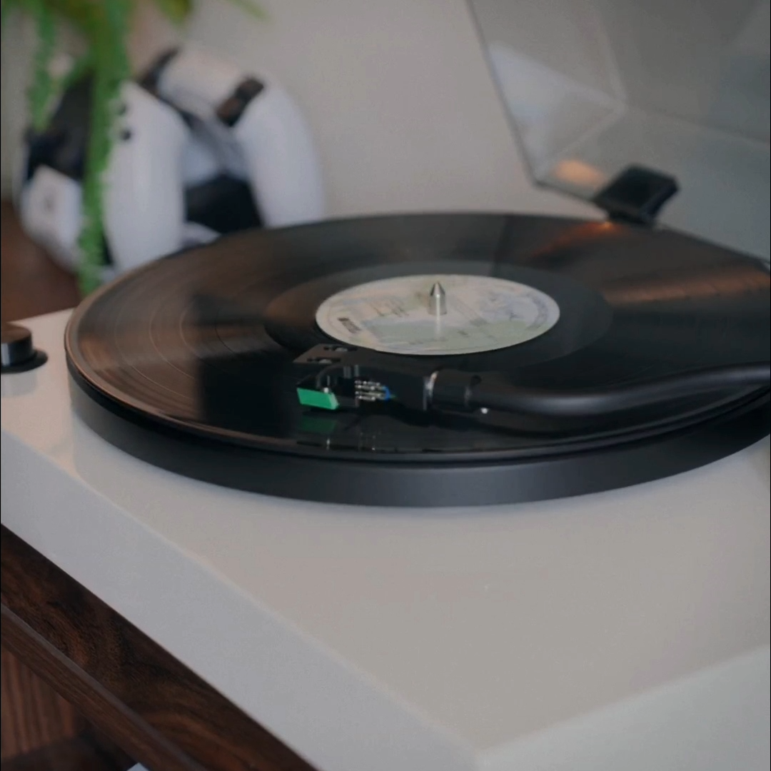 Close-up of a vinyl record spinning on a turntable with the cartridge tracking the groove